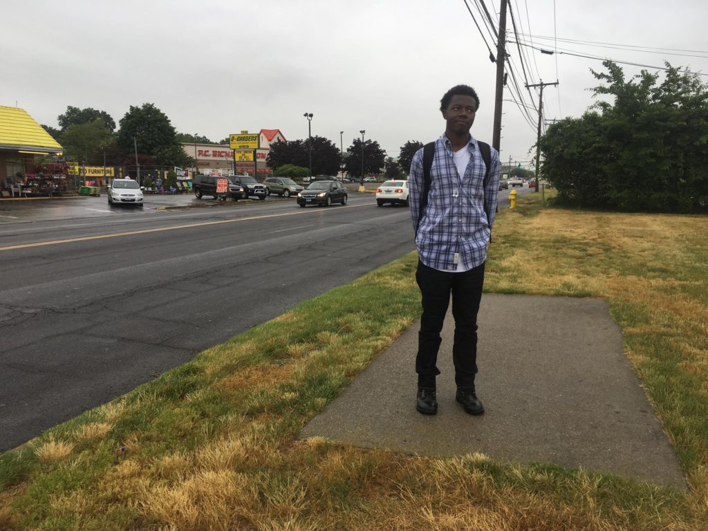 Jaelin McKenzie takes a bus from his home in Bridgeport to a mall in Milford, then walks about a mile on Route 1 to reach the Jos A. Bank clothing store where he works. Here, he's standing on a particularly confusing patch of sidewalk on Route 1. (Cassandra Basler/WSHU) 