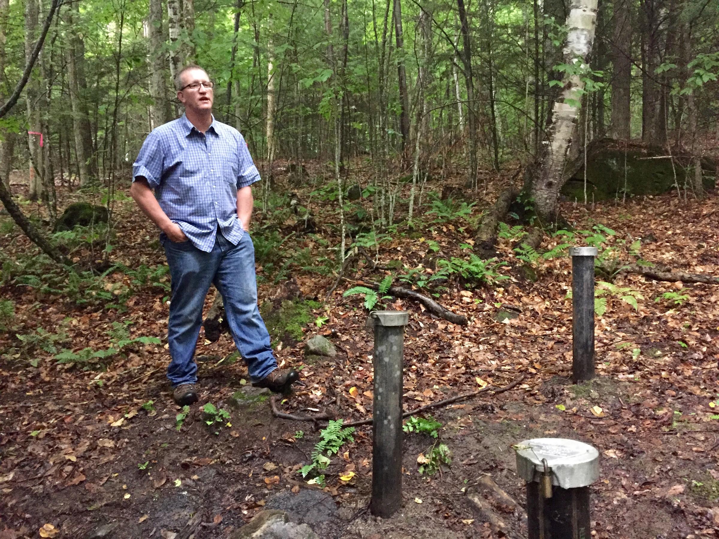 Hanover resident Richard Higgins stands near a well 375 feet away from his property, where groundwater tests have shown hundreds of times the New Hampshire state-alloted amount of the chemical 1,4-dioxane, a suspected carcinogen. REBECCA SANANES / VPR