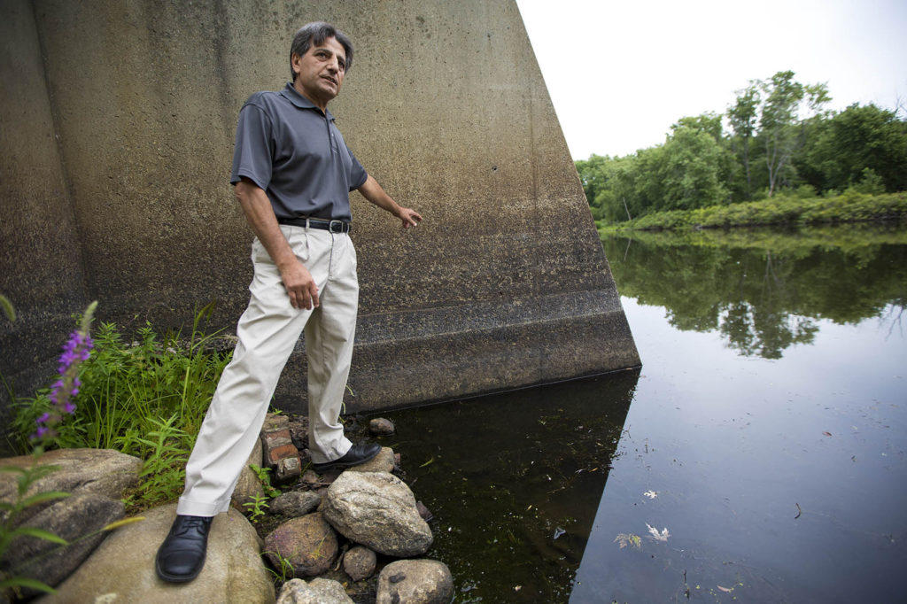 Director of the Billerica Public Works Abdul Alkhatib points out the level of the Concord River is three feet lower than it was this time last year in 2015 due to the current drought condtions this summer. (Jesse Costa/WBUR)