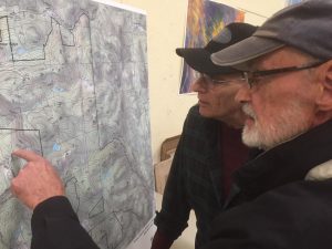 Residents of Windham, Vermont look over a map of the new layout for a proposed wind development. (Credit: Howard Weiss-Tissman/ VPR)