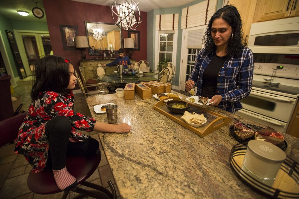 Asima Silva prepares snacks for her family at their home. Photo credit: Jesse Costa / WBUR 