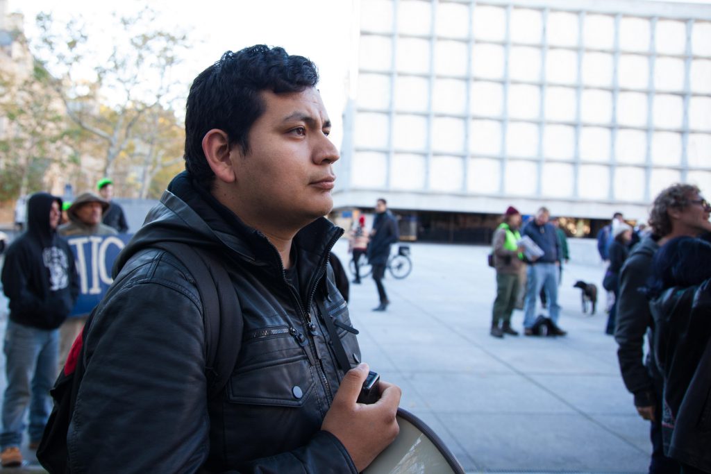 Jesus Sanchez stands in the back of a protest at Yale University. He says his favorite part of demonstrating is holding the megaphone. Credit: Ryan Caron King / WNPR