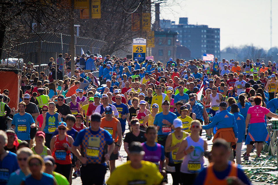 Runners pour over the Mass Pike overpass at mile 25 in the 2014 Boston Marathon. Photo by Jesse Costa for WBUR