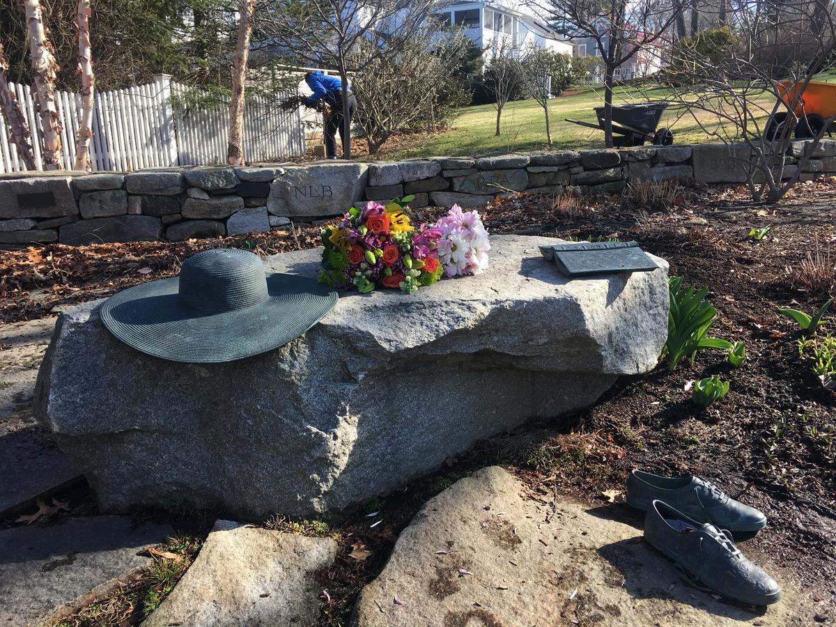 "Ganny's Garden" by the Kennebunkport Conservation Trust. Statuary is of her hat, her favorite book, Pride and Prejudice, and her Keds, which gardener Elizabeth Spahr says were always mismatched. Photo by Fred Bever for Maine Public