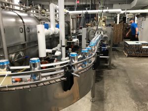 Aluminum cans of Citizen Cider's "Dirty Mayor" make their way on the canning belt at the company's Burlington canning facility. A new tariff on some imported steel and aluminum has Vermont craft brewers and cider makers bracing for uncertainty.