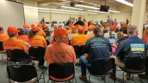 Orange-shirted opponents of Northern Pass sit with blue-shirted supporters at the Site Evaluation Committee Thursday. Photo by Annie Ropeik for NHPR