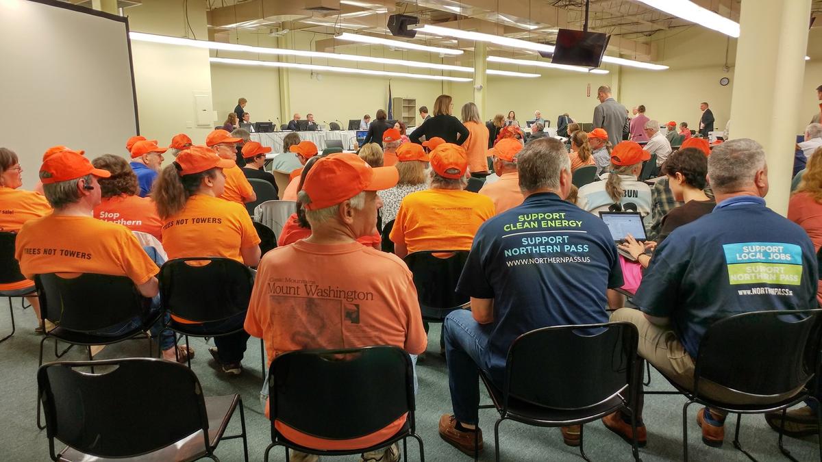 Orange-shirted opponents of Northern Pass sit with blue-shirted supporters at the Site Evaluation Committee Thursday. Photo by Annie Ropeik for NHPR