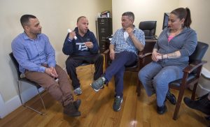 From left to right: Felito Diaz, Julio Cesar Santiago, Richard Lopez and Irma Bermudez speak at Casa Esperanza, a collection of day treatment, residential programs and transitional housing in Roxbury. Photo by Jesse Costa for WBUR