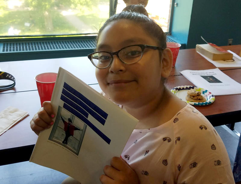 Angelina Morales holds her Connecticut history chapter book; Chapter 2 is about the African-American dancer, Dollie McLean. Photo by Tema Silk for NEPR