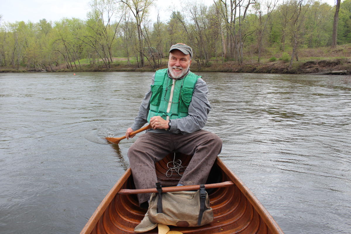 Norm Sims paddles one of his wood and canvas canoes on the Connecticut River. Photo by Annie Ropeik for NHPR