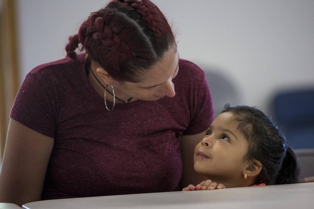 Genie Garda y su hija de 4 años, Getzaynoe Hernández, están a la mesa en la cena improvisada en Dracut, para mujeres evacuadas desde Puerto Rico. (Jesse Costa/WBUR)