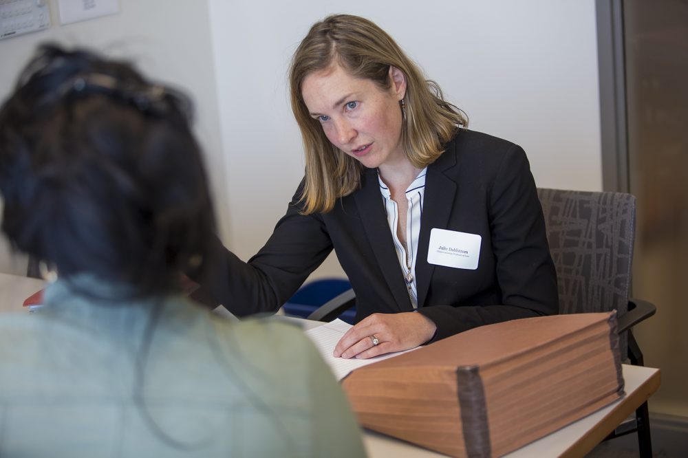 Julie Dahlstrom, directora del Programa de los Derechos de los Inmigrantes y Tráfico Humano de la Universidad de Boston, se reúne con un cliente que está esperando respuesta respecto a una Visa U que solicitó hace dos años. (Jesse Costa/WBUR)