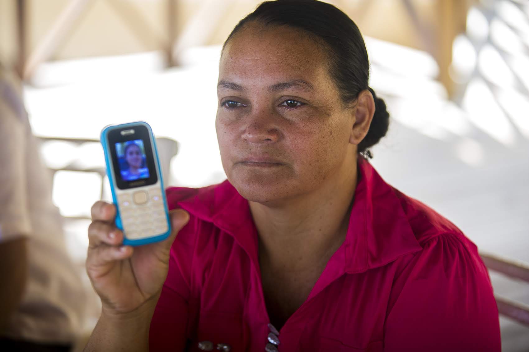 Rosa Lina Linder shows a photograph of her 16-year-old daughter on her cellphone, still being detained in the U.S. Photo by Jesse Costa for WBUR