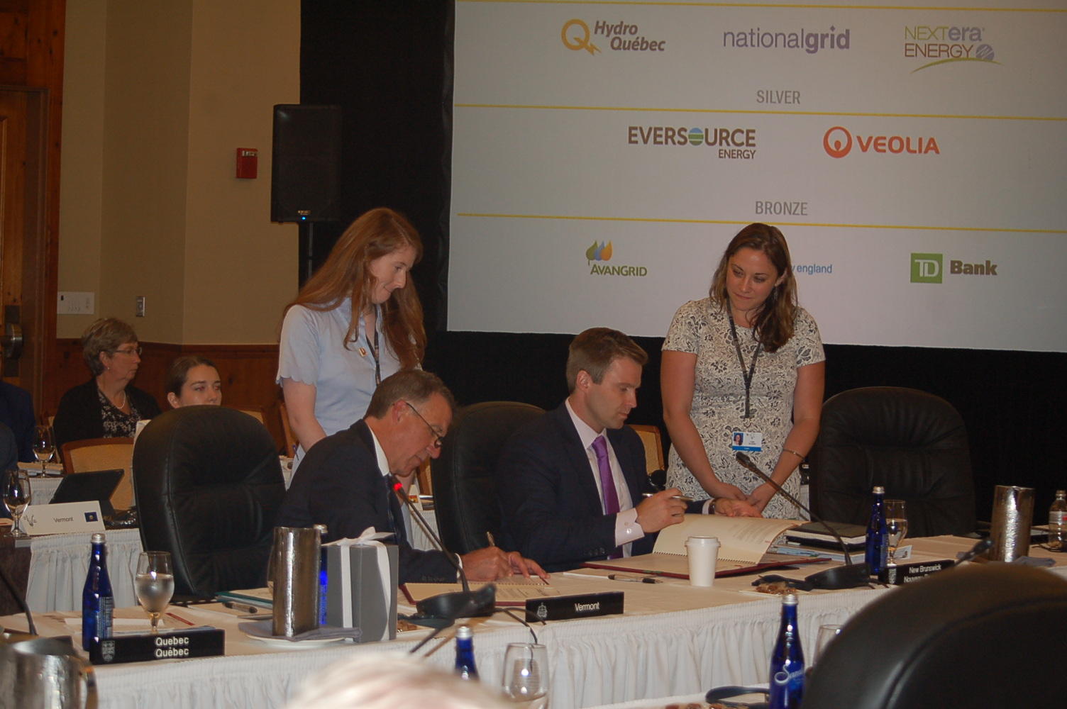 Vermont Gov. Phil Scott, left, and New Brunswick Premier Brian Gallant sign resolutions at Monday's annual conference of New England governors and eastern Canadian premiers. Gallant will host next year's meeting in St. John, New Brunswick. Photo by John Dillon for VPR