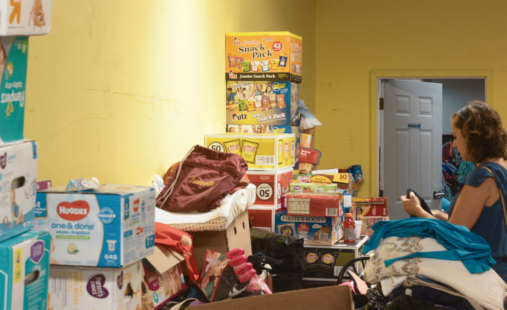 A person gathers essential belongings at House of Mercy. Photo by Quincy Walters for WBUR