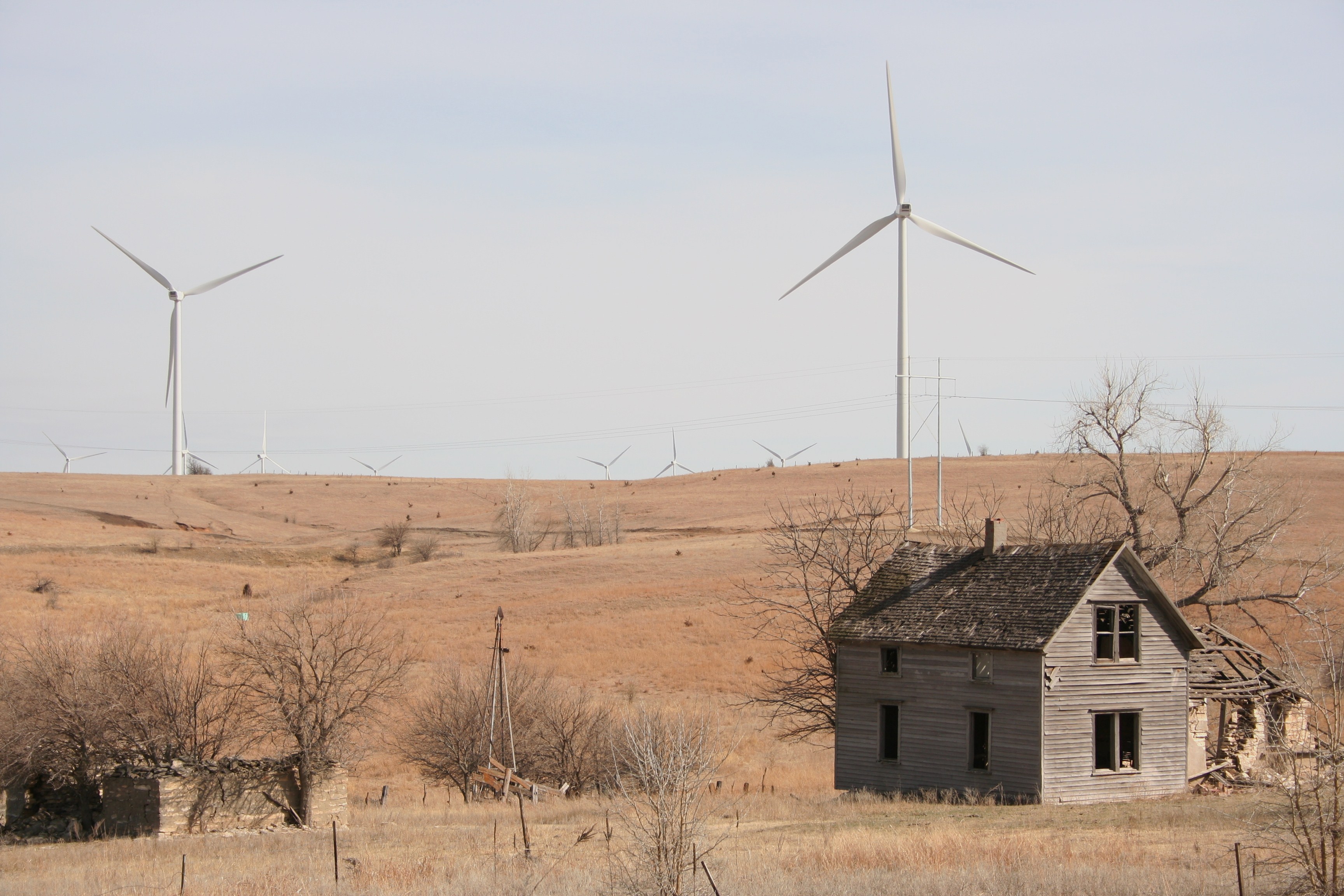 Abandoned farmhouse with turbines in background. Meridian Way Wind Farm, Cloud County, Kansas. Photo by Phil Warburg