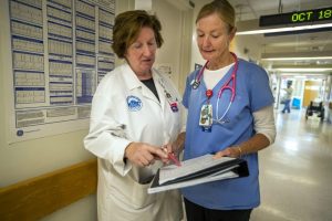 Theresa Capodilupo, a nurse director and Brenda Pignone, a bedside nurse, review the daily patient assignment sheet for White 7, a post-surgery and trauma unit at Massachusetts General Hospital. Photo by Jesse Costa for WBUR