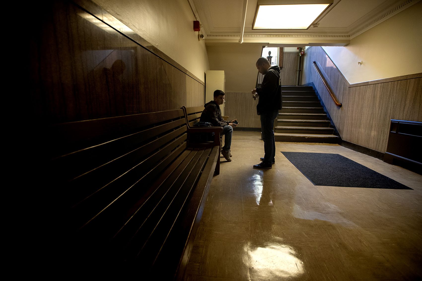 Diego Pizarro, a front line youth worker at Roca, stops to talk with a young man in East Boston District Court. Photo by Jesse Costa for WBUR