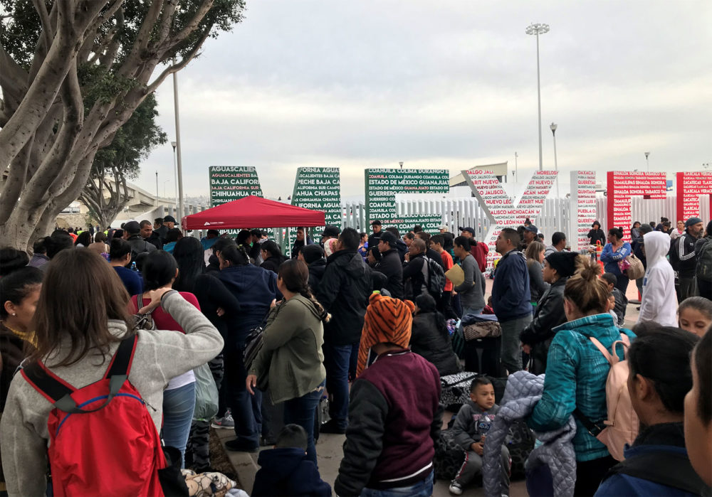 Families wait at "El Chaparral," a border crossing near San Ysidro, California, to hear which names are called from the asylum waitlist. Photo by Shannon Dooling for WBUR