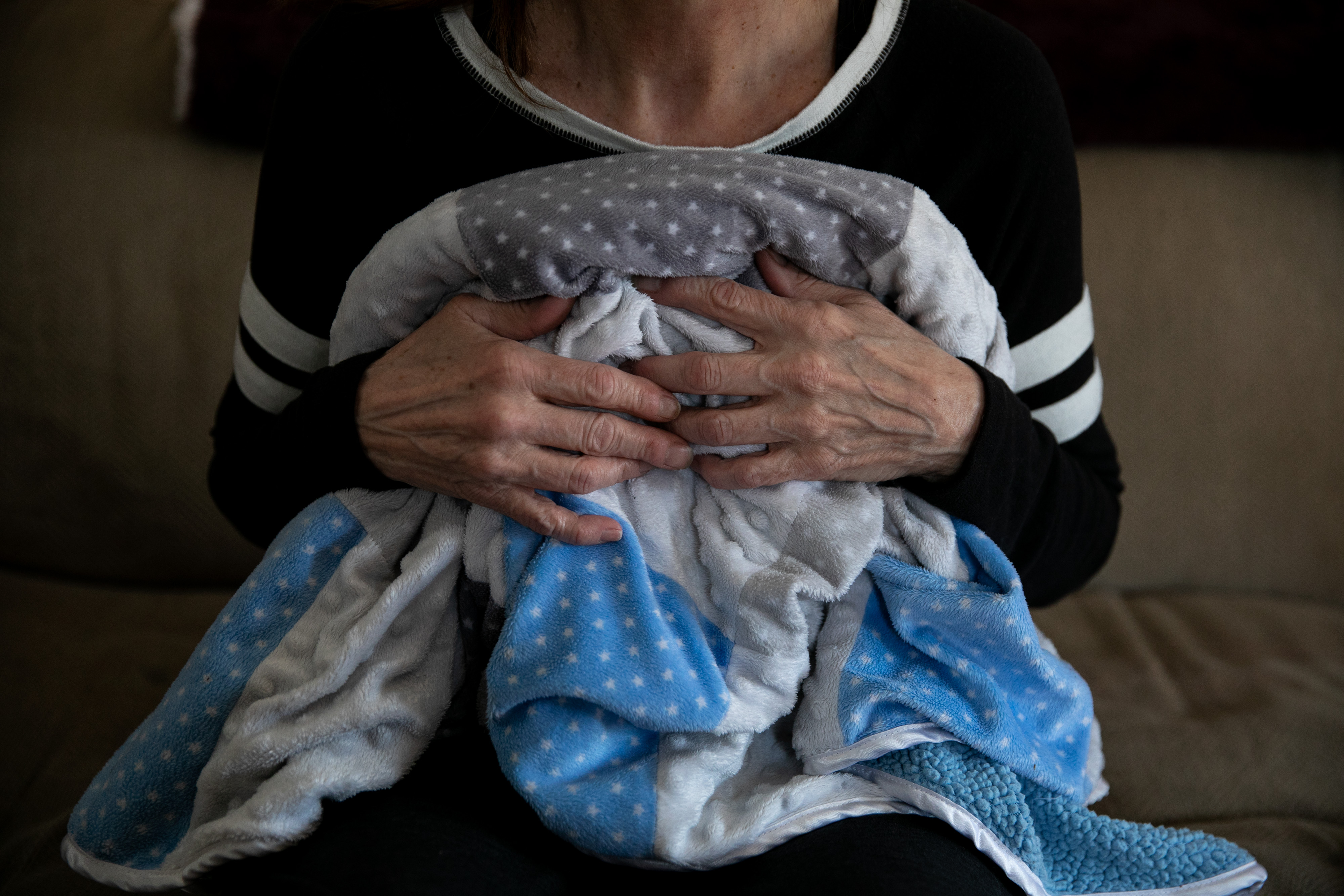  Barbara holds Elijah's baby blanket at her home on March 11, 2019, in Warwick, Rhode Island. Photo by Kayana Szymczak for ProPublica