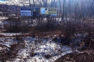 A billboard, at right, on Route 7 in Great Barrington, Massachusetts, was paid for by the mother of a man who says he was sexually abused decades ago in a now-closed elementary school in Sheffield. This one went up in February. Photo by Nancy Eve Cohen for NEPR
