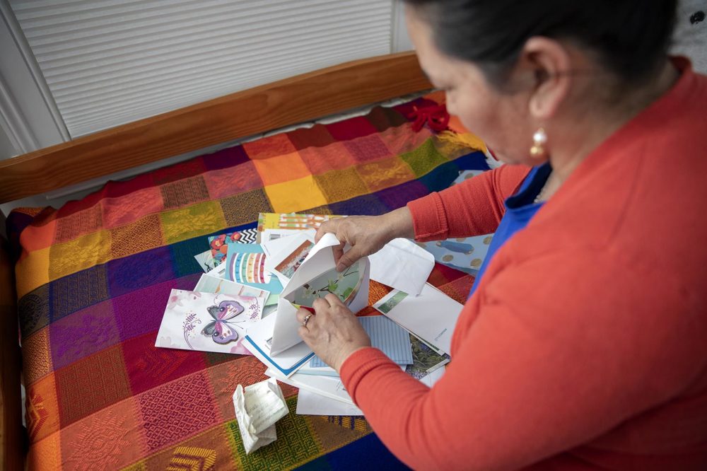 Maria Merida sifts through birthday cards she received last year from members of the church congregation where she’s been living in “sanctuary” for more than a year. Photo by Robin Lubbock for WBUR