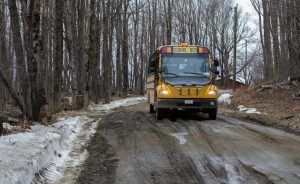 Joanne Deady's school bus navigates carefully over a icy lined and greasy mud covered Christian Hill Rd. Photo by Jesse Costa for WBUR