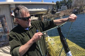 Ben Brickett tests out his time tension line cutter in the Piscataqua river. Photo by Fred Bever for Maine Public