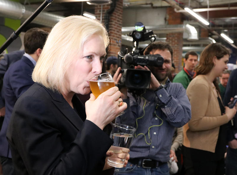 Photo by Allegra Boverman. U.S. Sen. Kirsten Gillibrand, a Democratic candidate for President, visited To Share Brewing Company in Manchester on Friday evening. There was a drink there named for her on tap, Kirstenweizen, which she sampled. Photo by Allegra Boverman for NHPR