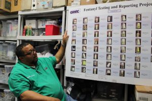 Mark Jenkins with Greater Hartford Harm Reduction Coalition shows a chart of recovered baggies of street drugs branded with names and logos. Photo by Cassandra Basler for WSHU