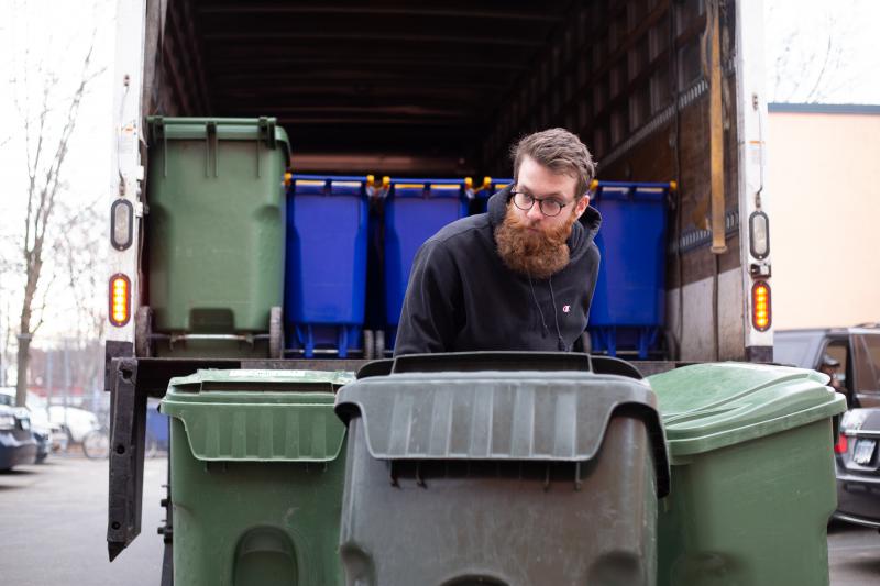 Alex Williams, with Blue Earth Compost, loads barrels of food waste into a truck during a recent food scrap pickup run in Hartford. Photo by Patrick Skahill for Connecticut Public Radio