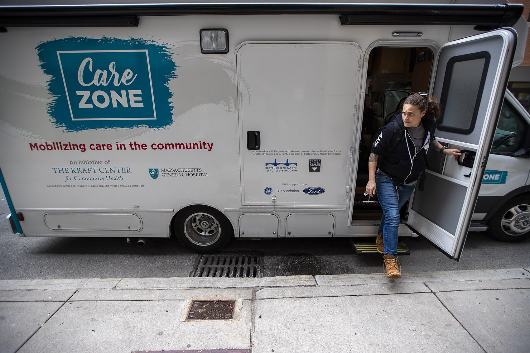 Sarah Mackin exits the Care Zone van after it parks on Haverhill St. near by North Station. They will mobilize and walk around the area to look for opioid users who need assistance. Photo by Jesse Costa for WBUR