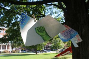 Newcomers to the Vermont Youth Lobby hung up drawings related to climate change on the Statehouse lawn.