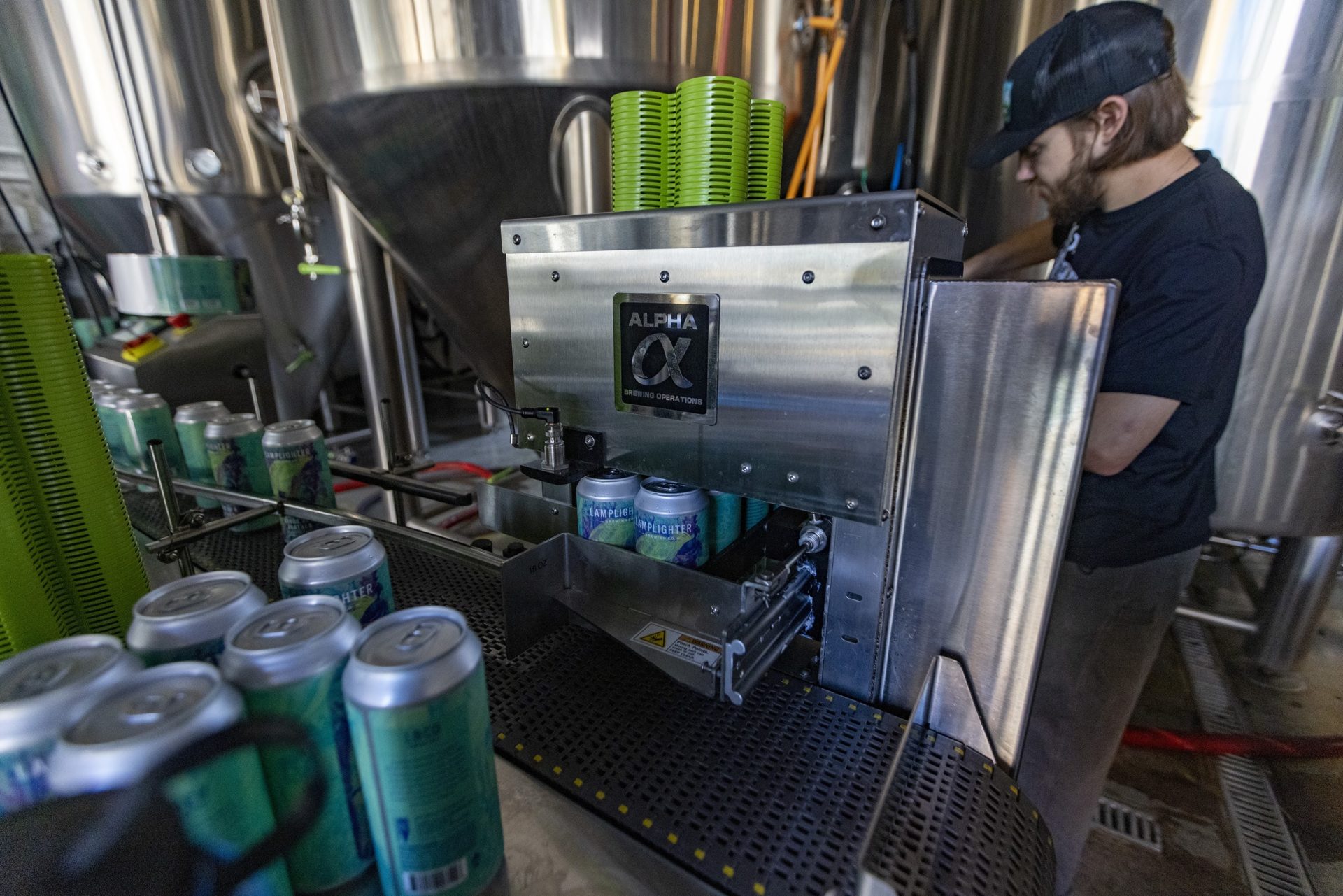 Cans of Birds of a Feather India Pale Ale travel through the Pack Tech Applicator placing plastic carriers onto each 4 pack. 