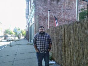 A photo of Jonathan Soto standing on a sidewalk in Holyoke, Mass. Soto survived Hurricane Maria and arrived here from Puerto Rico a few years ago.