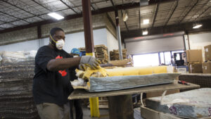 A worker handles mattress foam in a warehouse in Connecticut.