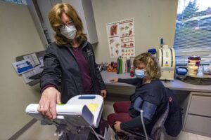 Physical therapist Heather Brolio takes the blood pressure reading of long COVID patient Holly Gochis during a physical therapy session at Beth Israel Deaconess Medical Center, Lexington.