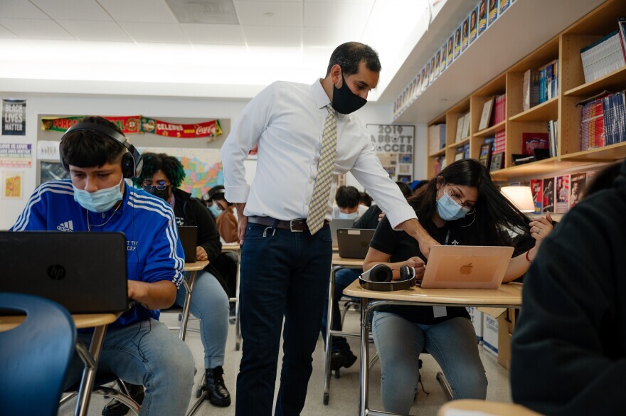 Adrian Solis, a social studies teacher at Abbott Technical High School social, walks around the classroom during a Black and Latino history class as his students learn about demographics, economics and the history of slavery in Connecticut.