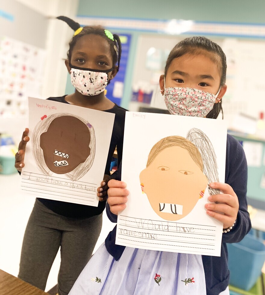 Vermont first-graders Happiness Alex and Emily Xia display art and writing projects in which they imagined themselves with different kinds of animal teeth. Their class is an even mix of English learners and native English speakers.