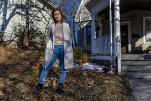 A portrait of Brighton High School nurse Lauren O'Malley-Singh, standing outside on her front lawn.