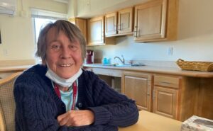 Linda Larson, 74, of Cambridge, Mass., sits at a kitchen table. She is advocating for a new name for schizophrenia