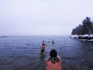 Gisela Veve follows her fellow Red Hot Chilly Dippers into the water at Oakledge Cove in Burlington, Vt., just after dawn on Dec. 9, 2021. Gisela joined the group shortly after her husband, Rafael, passed away.