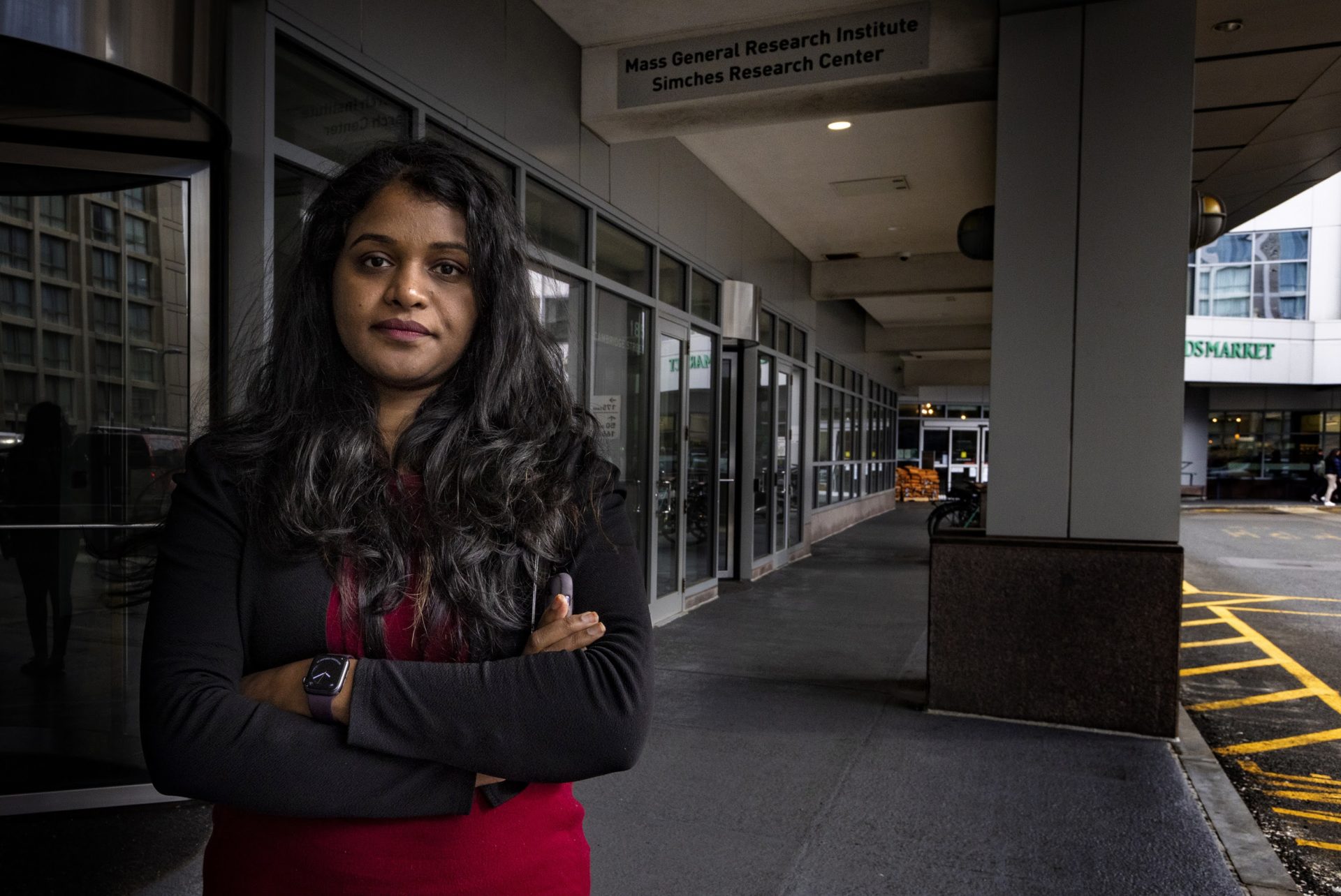 Aatira Vijay in front of the entrance of the Simches Research Center at Massachusetts General Hospital. 