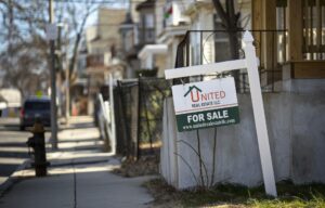 A "For Sale" sign by a house on Ballou Ave. in Mattapan.