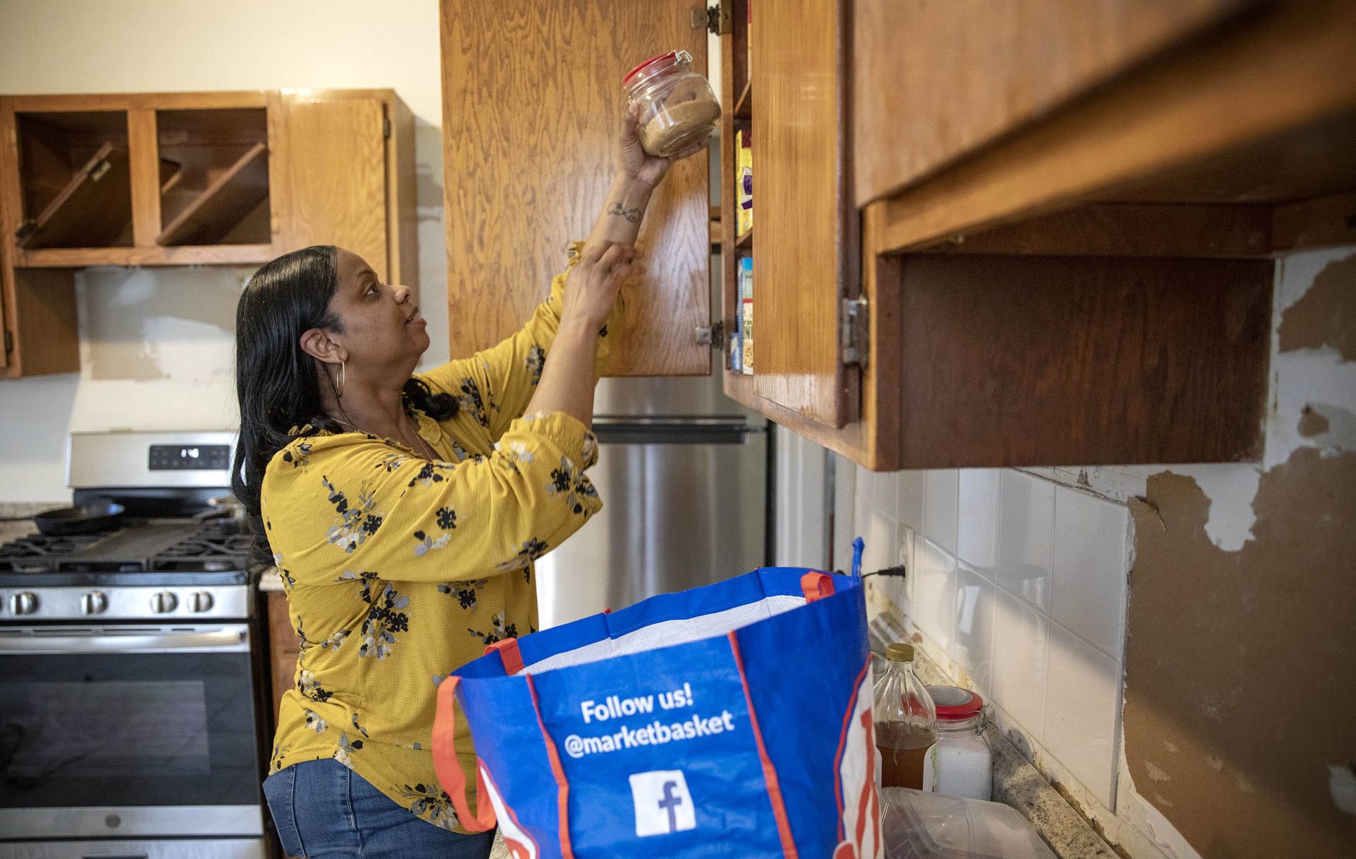 With redecorating under way at her new home in Dorchester, Cecilia Dixon unloads groceries in her kitchen.