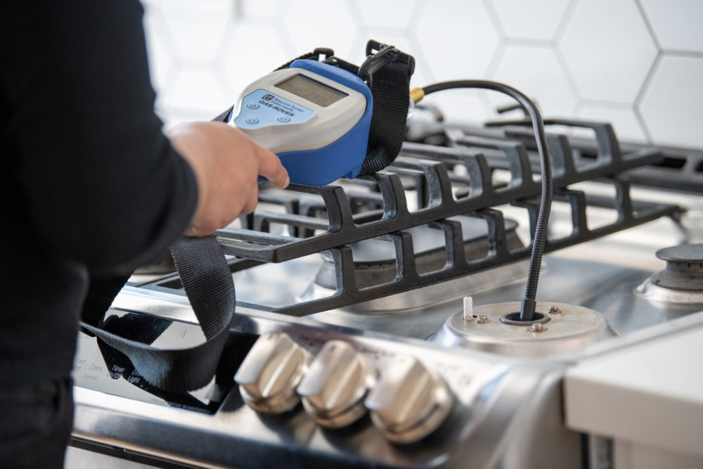 A researcher takes a gas sample from a stove. 