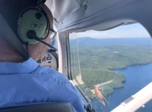 Forester Kyle Lombard looks out the window of the small airplane, searching for damage in the New Hampshire forest below.