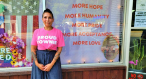 Miriam Kovacs stands in front of her Franklin, N.H. catering business, wearing a pink T-shirt that reads "PROUD TOWNIE." Kovacs has been a target of online harassment by white supremacists since she made a point of protesting their presence in New England.