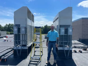 Brian Sands, Director of Facilities for New Hampshire's Pelham School District, stands in front of a unit for the school’s new AC system.