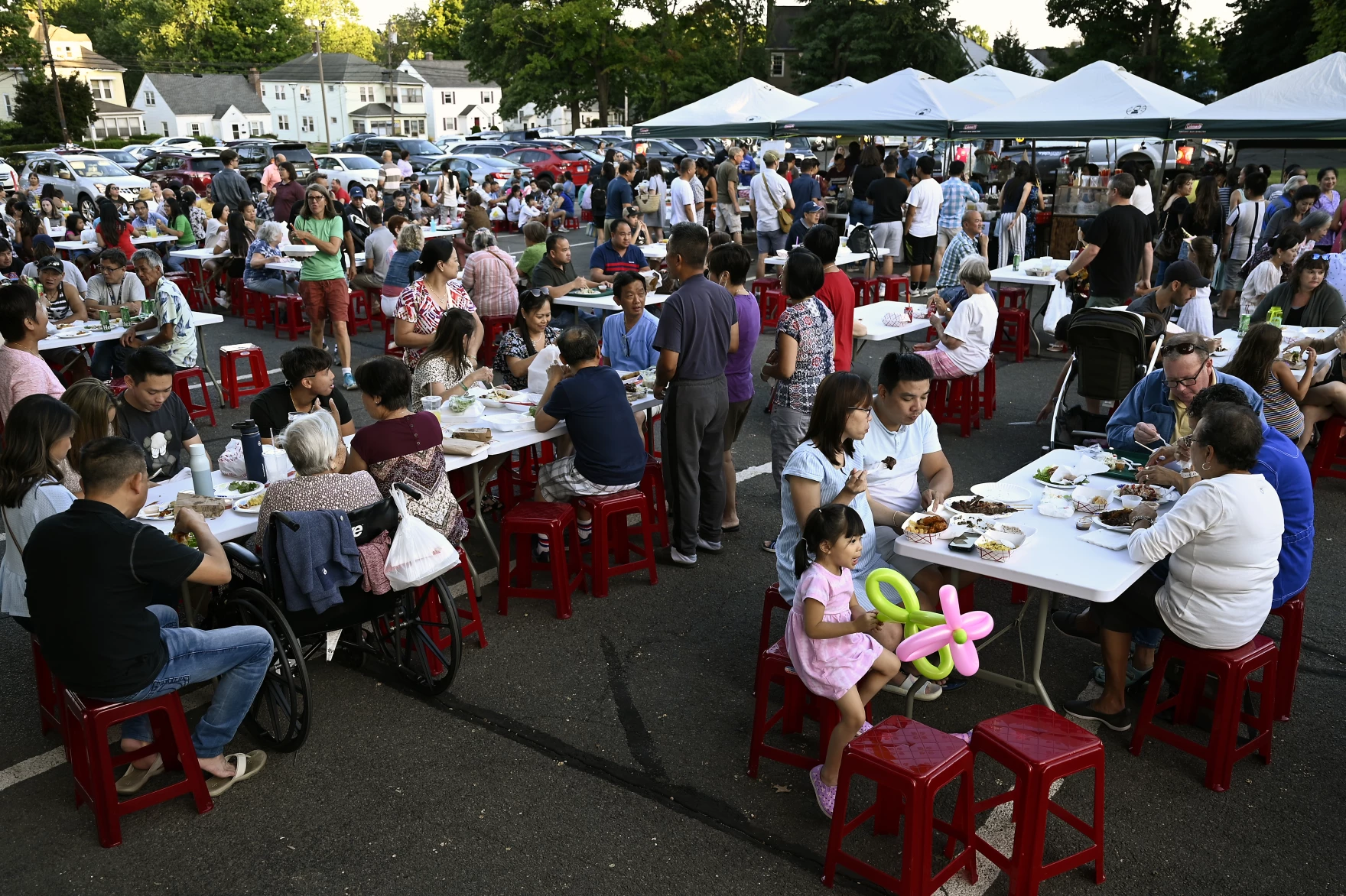 Family and friends fill the tables and tents for food during the Mid-Autumn Festival celebrated by St. Andrew Dung-Lac Parish in West Hartford, Connecticut, Sept. 3, 2022.